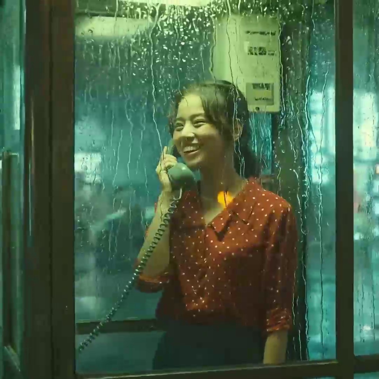 雨夜窗边接听电话的女性，呈现电影叙事氛围
